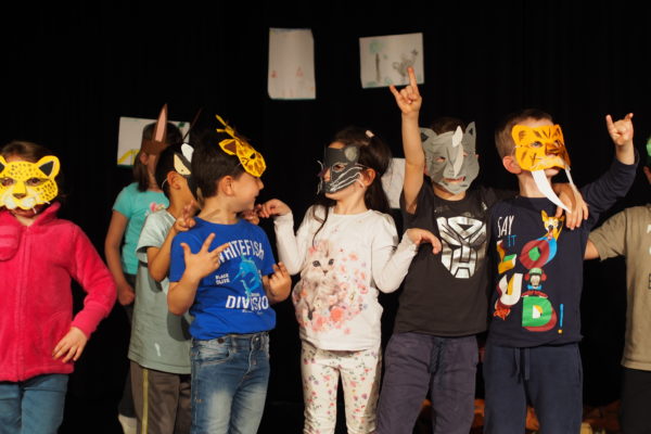 Kinder spielen Theater auf der Bühne verkleidet mit Tiermasken